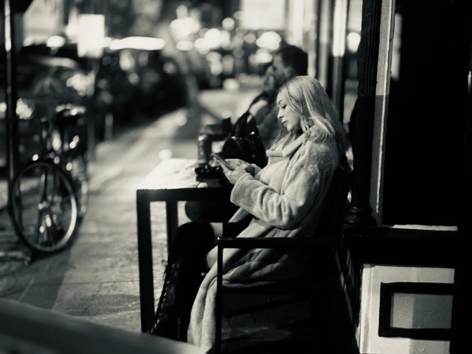 Untitled (Sidewalk Cafe), black and white photograph by Mathieu: a sidewalk cafe at night
