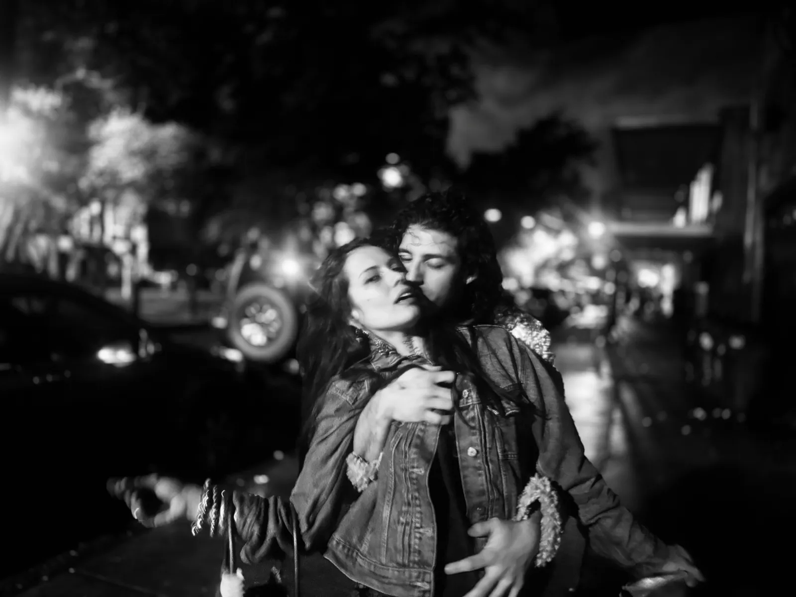 Untitled (The Embrace), black and white photograph by Mathieu: a couple embracing on a night street