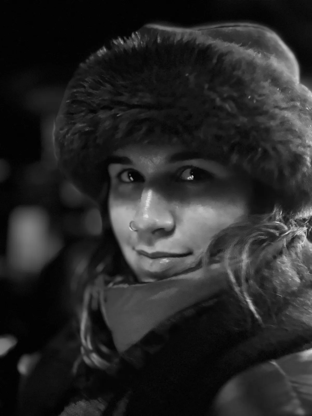 Untitled (Fur Hat), black and white photograph by Mathieu: a night portrait of a person in a fur hat and scarf