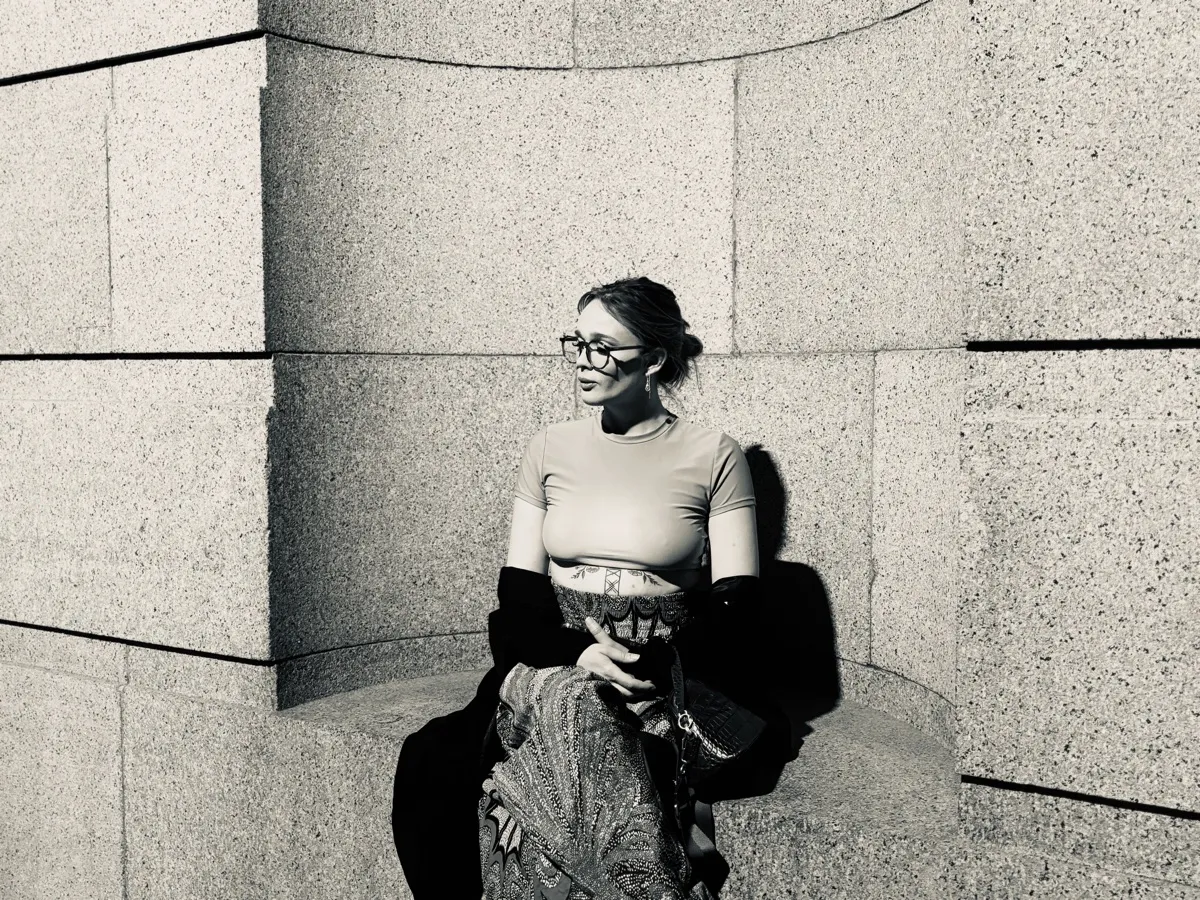 Untitled (Granite), black and white photograph by Mathieu: a woman seated in a curved granite alcove