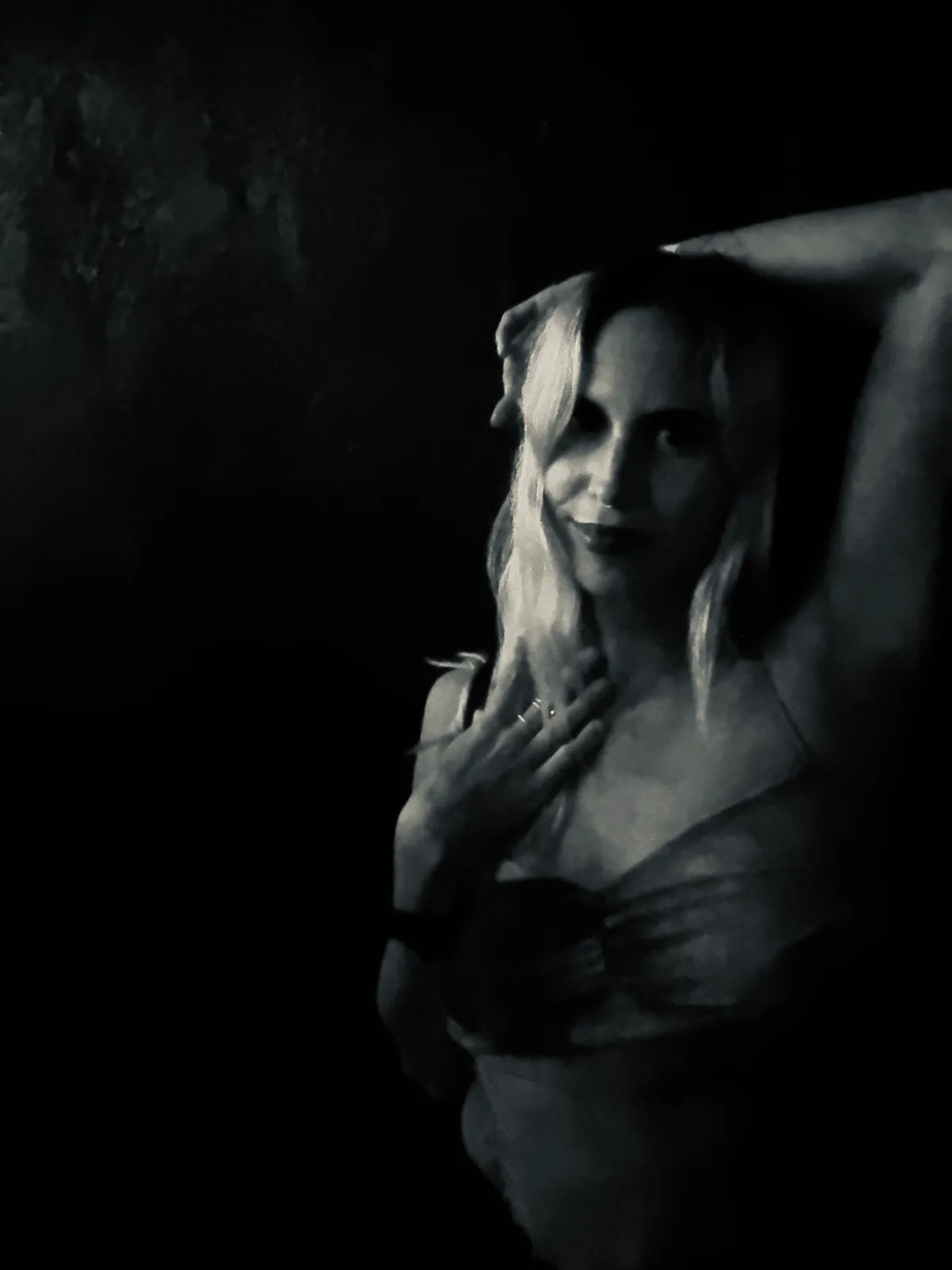 Untitled (In the Dark), black and white photograph by Mathieu: a woman half lit against deep shadow