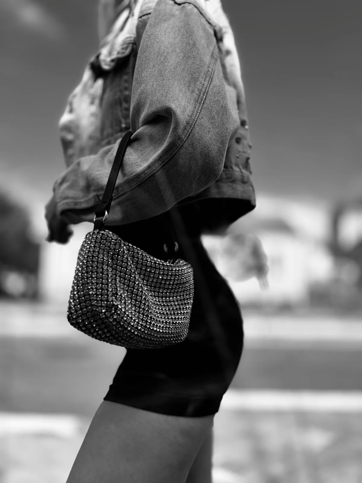 Untitled (Rhinestones), black and white photograph by Mathieu: a rhinestone handbag against denim, mid stride