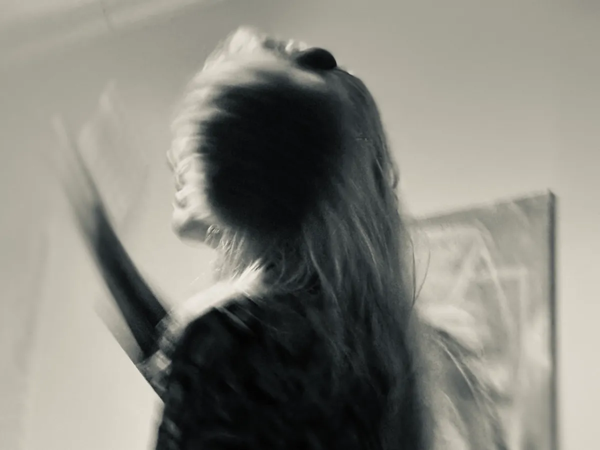 Untitled (Turning), black and white photograph by Mathieu: a figure in motion, hair swept across the frame
